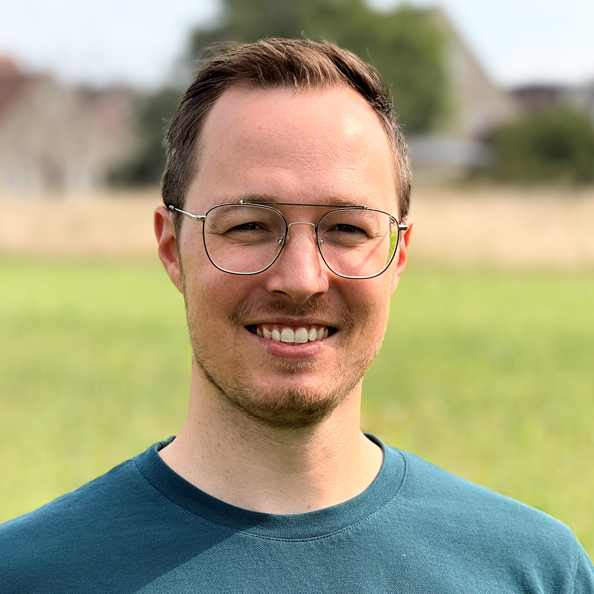 Ein Mann mit Brille lächelt in die Kamera