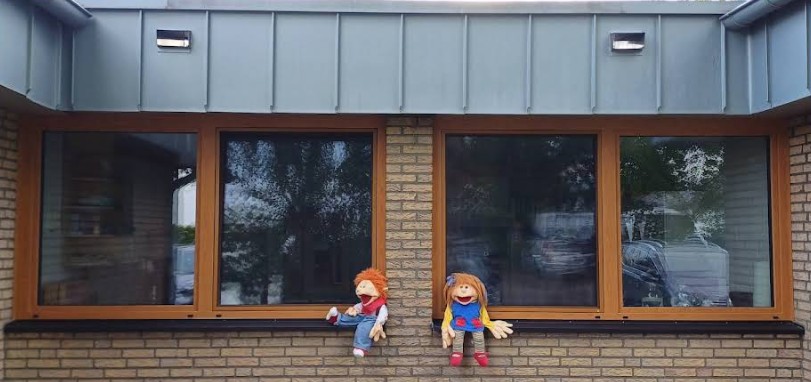 Zu sehen ist ein neu eingebautes Fenster. Davor sitzen zwei Kuscheltiere